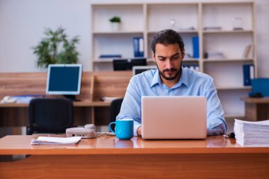 Ofiste çalışan genç bir erkek.