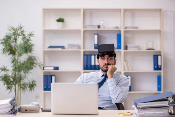 Mladý muž zaměstnanec nosí virtuální brýle na pracovišti — Stock fotografie
