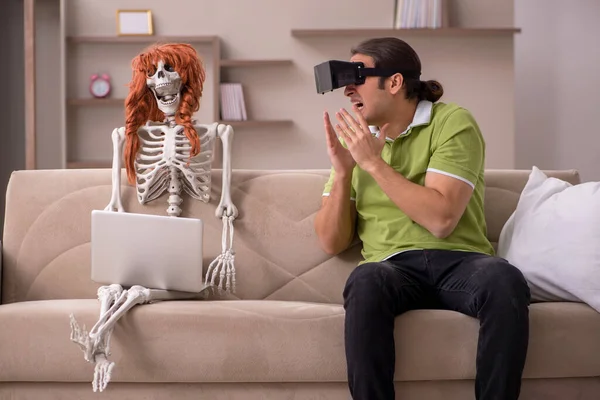 Young man with female skeleton in virtual reality concept