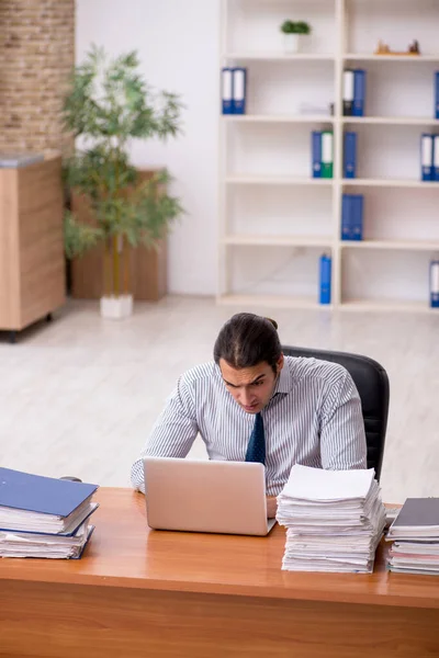 Jovem funcionário masculino infeliz com excesso de trabalho no escritório — Fotografia de Stock