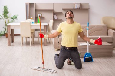 Genç erkek müteahhit evi temizliyor.