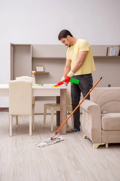 Joven contratista masculino limpiando la casa — Foto de Stock