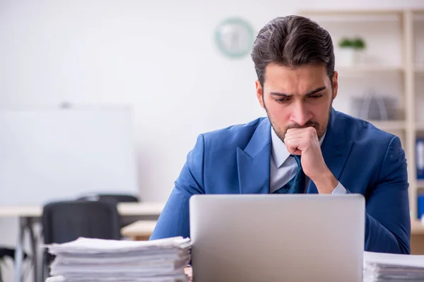 Empleado joven de negocios y demasiado trabajo en la oficina —  Fotos de Stock