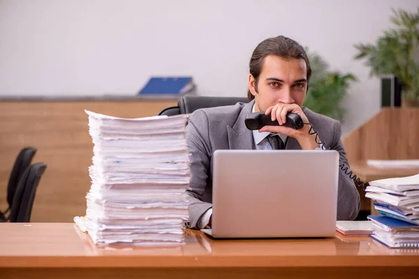 Jonge mannelijke werknemer en te veel werk op kantoor — Stockfoto