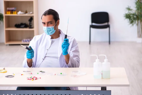 Jovem químico do sexo masculino trabalhando no laboratório durante a pandemia — Fotografia de Stock