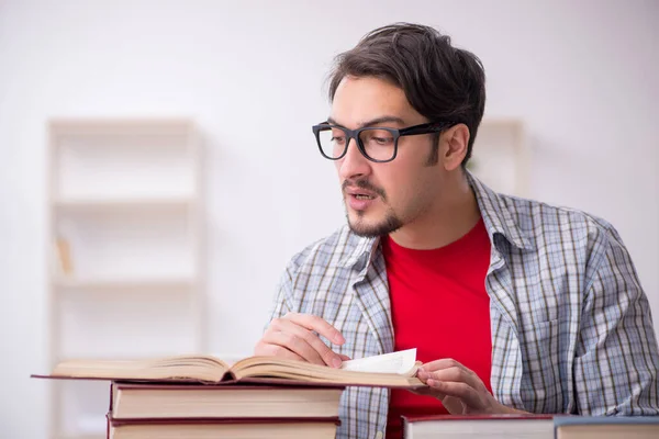 Junge männliche Schüler und zu viele Bücher im Klassenzimmer — Stockfoto