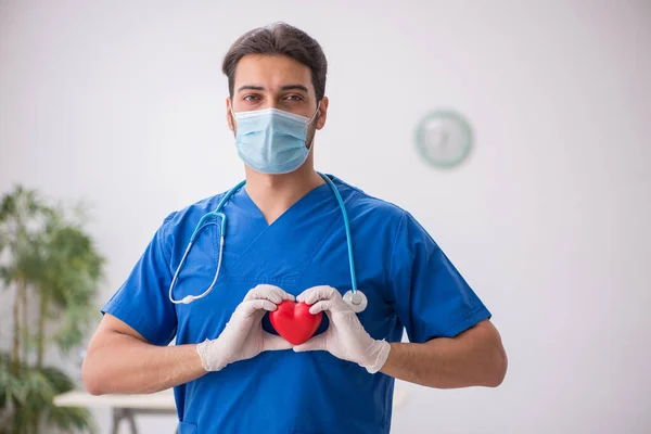 Giovane medico cardiologo maschile che lavora in clinica durante la pand — Foto Stock