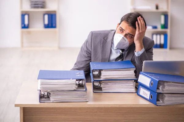 Junge männliche Mitarbeiter arbeiten während der Pandemie am Arbeitsplatz — Stockfoto