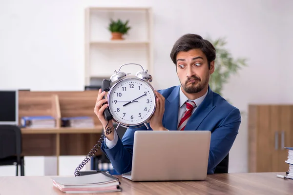 Giovane dipendente maschile nel concetto di gestione del tempo sul posto di lavoro — Foto Stock