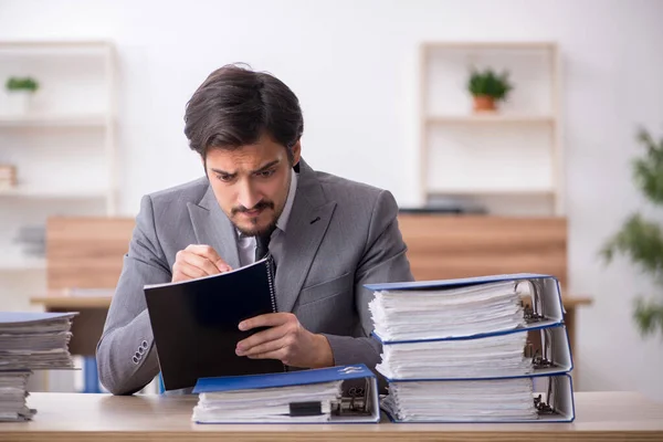 Jovem funcionário masculino infeliz com excesso de trabalho no escritório — Fotografia de Stock