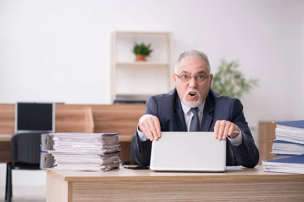 Hombre anciano empleado sentado en el lugar de trabajo — Foto de Stock