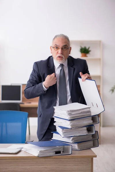 Gammal manlig anställd som sitter på arbetsplatsen — Stockfoto