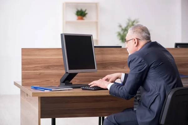 Dipendente di sesso maschile anziano seduto sul posto di lavoro — Foto Stock