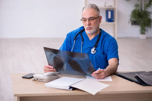 Gammal manlig röntgenläkare som arbetar på kliniken — Stockfoto