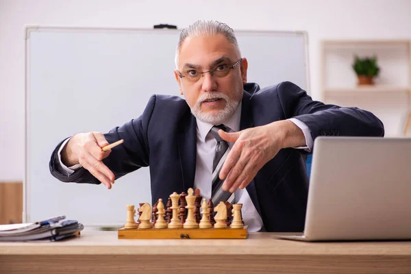 Ancien employé masculin jouant aux échecs sur le lieu de travail — Photo