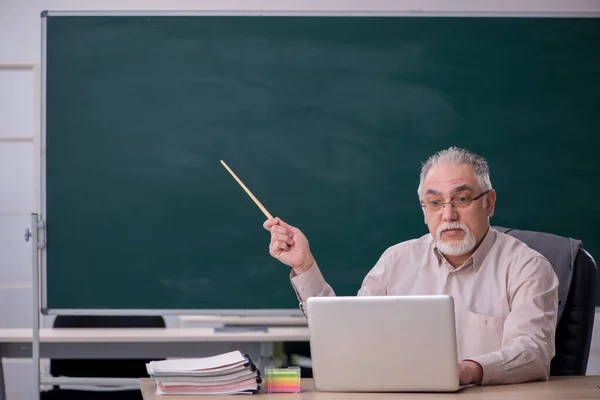 教科書の概念で黒板の前で古い男性教師 — ストック写真
