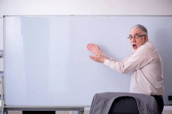 Velho professor masculino na frente do quadro branco — Fotografia de Stock