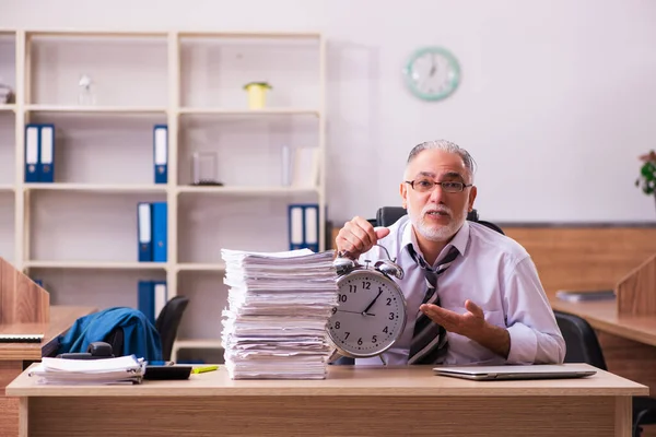 Старий чоловік-працівник незадоволений надмірною роботою в офісі — стокове фото