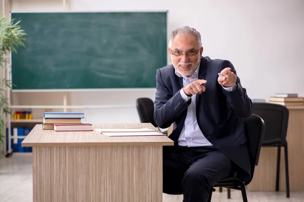 Tahtanın önünde yaşlı bir erkek öğretmen. — Stok fotoğraf