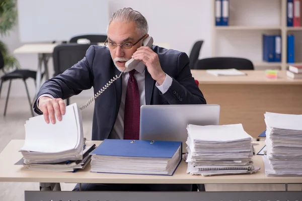 Überalterte männliche Mitarbeiter und zu viel Arbeit am Arbeitsplatz — Stockfoto