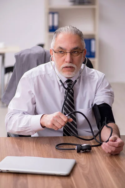 Leeftijd mannelijke werknemer lijden op de werkplek — Stockfoto