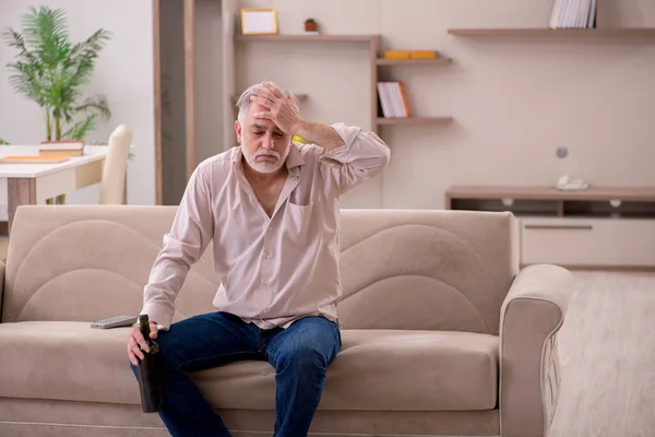 Viejo bebiendo alcohol en casa — Foto de Stock