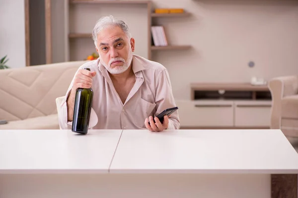 Old man drinking alcohol at home — Stock Photo, Image