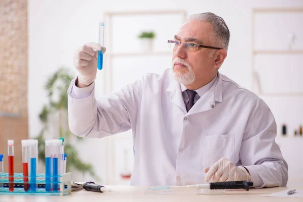 Oude mannelijke chemicus werkt in het lab. — Stockfoto