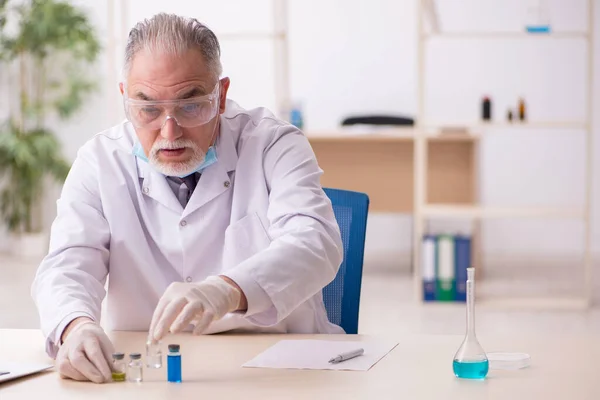 Oude mannelijke chemicus werkt in het lab tijdens een pandemie — Stockfoto