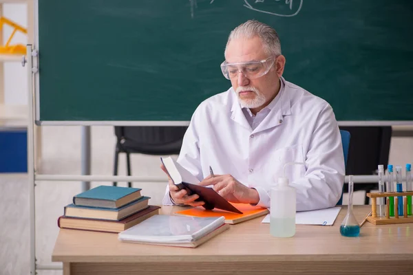 Starý muž chemik učitel ve třídě — Stock fotografie