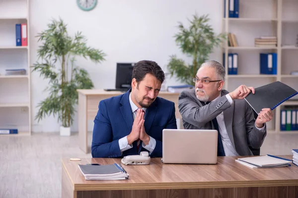 Two male employees working in the office in bullying concept — Stock Photo, Image