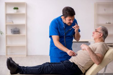 Yaşlı erkek hasta, genç doktor.