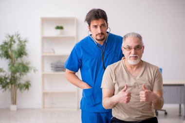 Yaşlı erkek hasta, genç doktor.