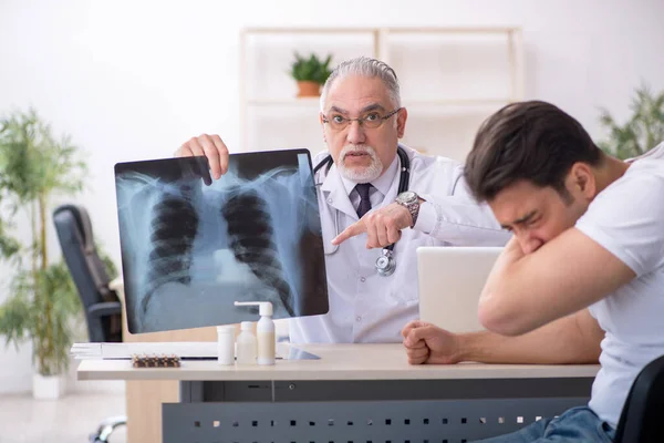 Jonge mannelijke patiënt op bezoek bij oude mannelijke arts radioloog — Stockfoto