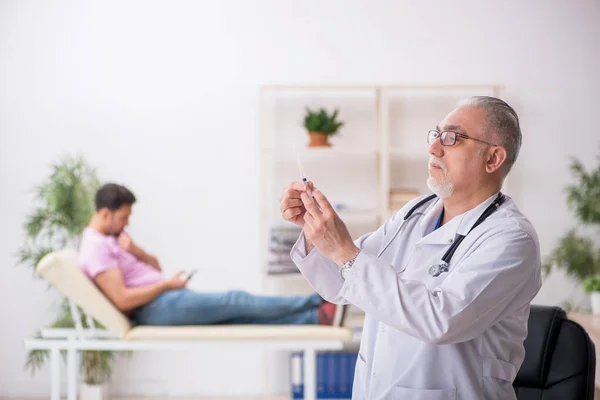 Vieux médecin et jeune patient masculin dans le concept de vaccination — Photo