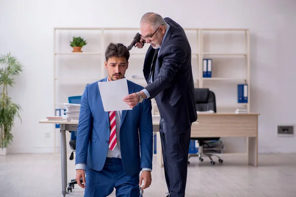 Viejo jefe y joven empleado masculino en concepto de intimidación —  Fotos de Stock