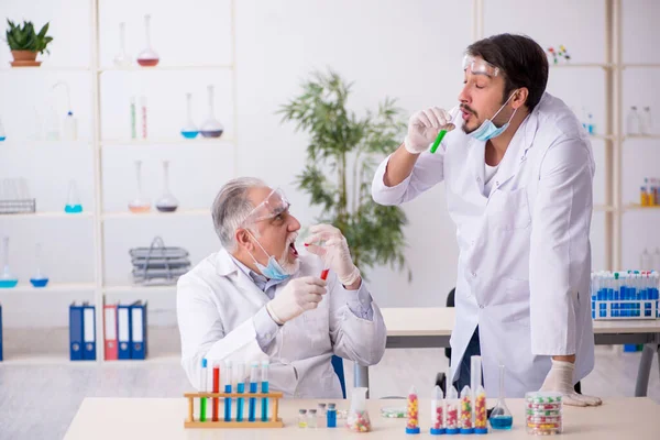 Dois químicos do sexo masculino no conceito de síntese de drogas no laboratório — Fotografia de Stock