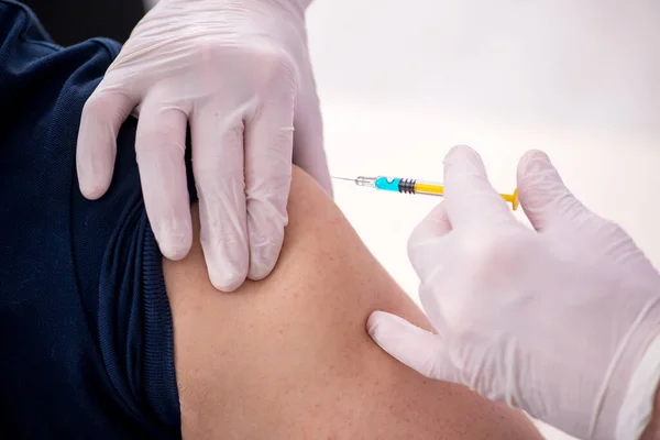 Ung manlig patient besöker gammal manlig läkare i vaccinationsgrupp — Stockfoto