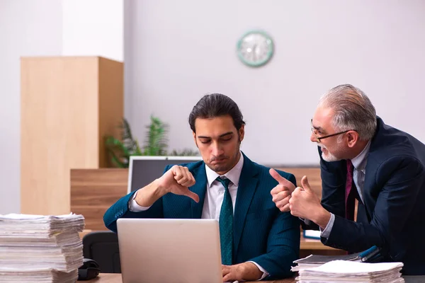 Viejo empleador masculino y joven asistente masculino en concepto de bullying —  Fotos de Stock