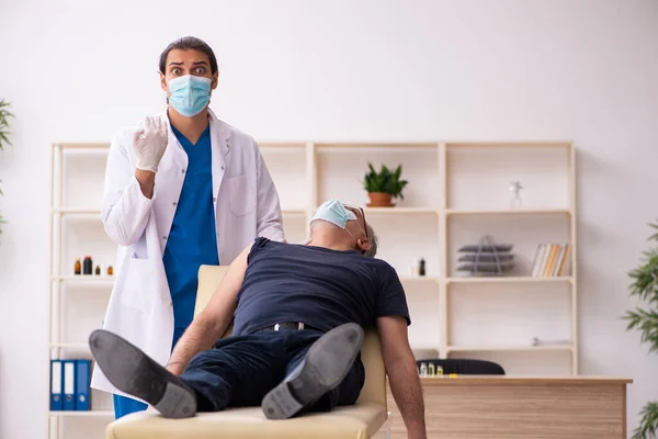 Vieil homme visitant jeune médecin dans le concept de vaccination covid-19 — Photo