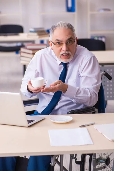 Viejo empleado masculino en silla de ruedas bebiendo café durante el descanso — Foto de Stock