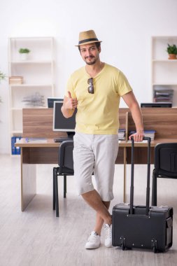 Genç bir erkek işçi iş yerinde geziye hazırlanıyor.