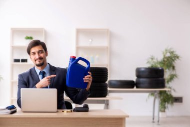 Genç adam araba teçhizatı satıcısı elinde bidon tutuyor.