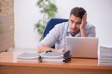 Genç işadamı ve ofiste çok fazla iş var.