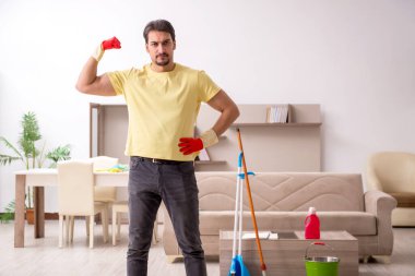 Genç erkek müteahhit evi temizliyor.
