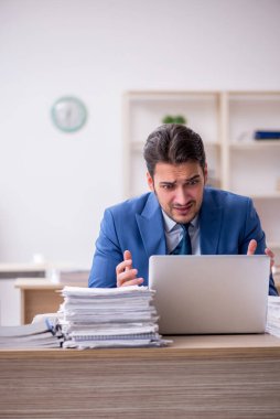 Genç işadamı ve ofiste çok fazla iş var.