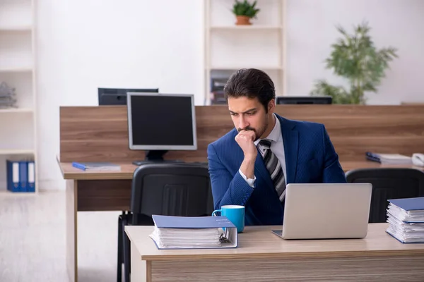 Jeune employé masculin et trop de travail au bureau — Photo