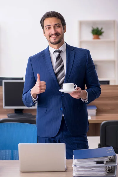 Junge männliche Angestellte trinkt in der Pause Kaffee — Stockfoto