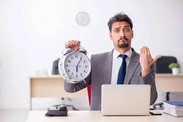 Joven empleado masculino en concepto de gestión del tiempo —  Fotos de Stock