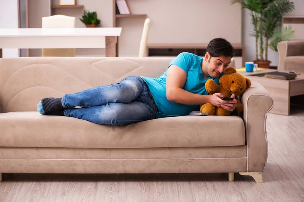Joven sentado con oso juguete en casa —  Fotos de Stock